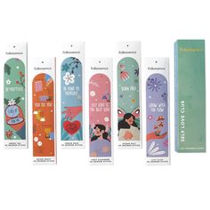 four different colored skateboards are lined up in a row and one is empty, the other has an image of snowboarding on it