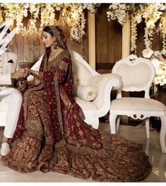 a bride and groom sitting on a white couch