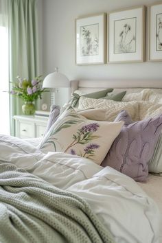 a bed with pillows, blankets and pictures on the wall