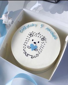 a white cake with blue frosting in a box