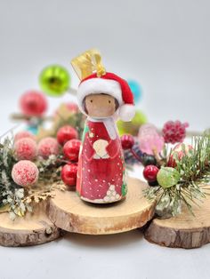 a small figurine is standing on a piece of wood with ornaments around it