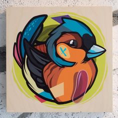 a painting of a colorful bird sitting on top of a wooden plaque with an x in it's center