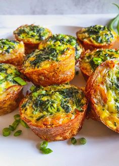 small quiches with spinach and cheese on a white plate