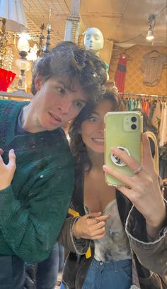 two people taking a selfie in a clothing store