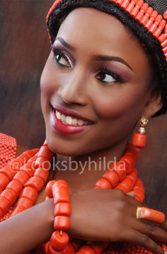 an african woman with bright orange necklaces