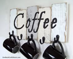 three black coffee mugs are hanging on a wall with the word coffee spelled out