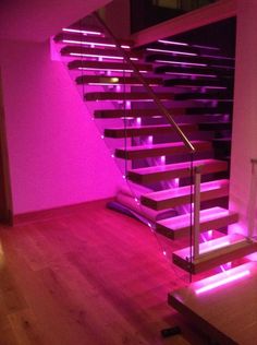 the stairs are lit up with pink lights in this room, and it looks like they have been painted