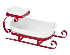 two red and white dishes sitting on top of a wooden sleigh with handles