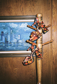 a pair of wooden shoes hanging on a pole in front of a painting with cityscape