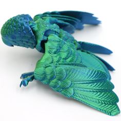 a blue and green toy lizard on a white surface