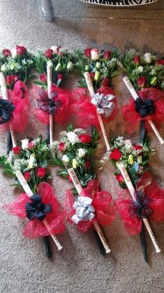 red and white flowers are arranged on the floor next to each other with black bows