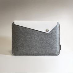 a gray and white felt case with a button on it