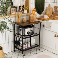 a kitchen with white tiles and wooden counter tops, including a potted plant on the shelf