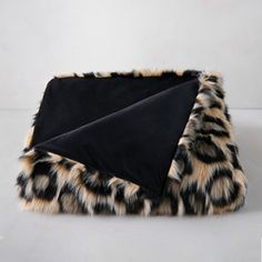 a black and brown animal print blanket laying on top of a white surface