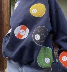 a person wearing a blue sweatshirt with different colored buttons on the front and back of it