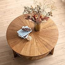 a wooden table with a vase on top of it next to a couch and coffee table