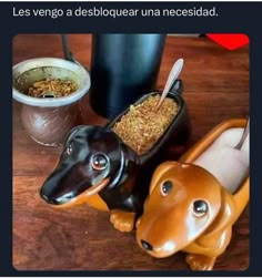 a dachshund dog sitting on top of a wooden table next to two cups