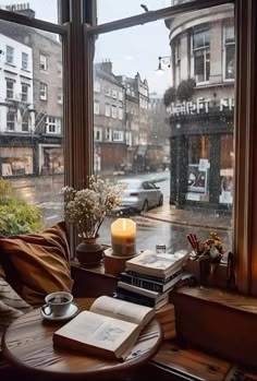 an open book sitting on top of a table next to a window with a view of the street