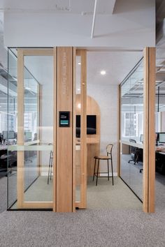 an office with glass walls and wooden doors