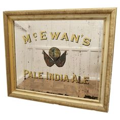 an old framed sign that says mc ewan's pale india ale