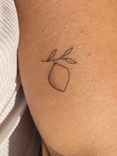 a small tattoo on the back of a woman's left arm, depicting an apple