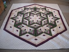 a quilted table topper on the floor in front of a wooden dresser and chair