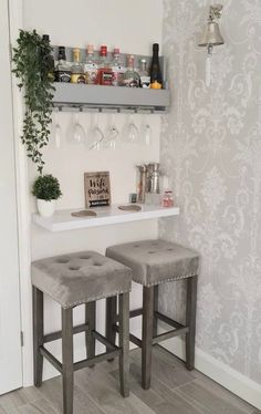 two gray stools sitting in front of a bar