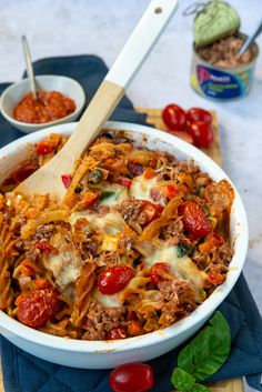 a large white bowl filled with pasta and meat