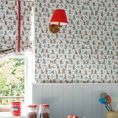 a red lamp hanging from the side of a kitchen wall