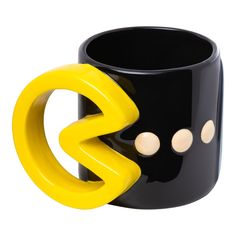 a black and yellow coffee mug with two white circles on the front, and one in the middle