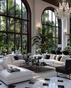 an elegant living room with black and white furniture, chandelier and large windows