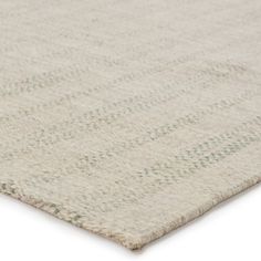 an area rug with white and green designs on the top, in front of a white background