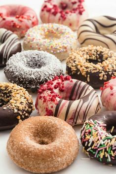 a bunch of doughnuts that are sitting on a table with sprinkles