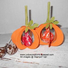 some candy and candies are sitting on a white table with two orange pumpkins