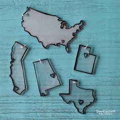 some metal pieces sitting on top of a wooden table with the shape of the united states cut out