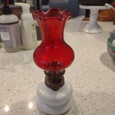 a red glass vase sitting on top of a counter