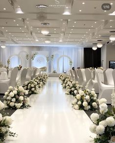 a long table with white chairs and flowers in the center is set up for a wedding ceremony