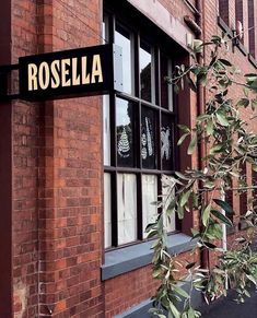 there is a sign that says rosella on the side of a red brick building