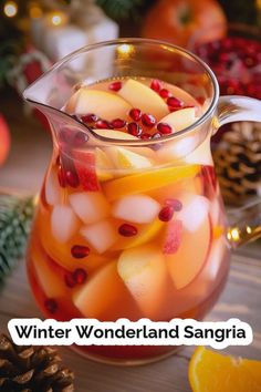 winter wonderland sangria with oranges and pomegranate in a glass pitcher