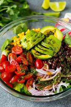 a salad with tomatoes, avocado, black beans, corn and cilantro