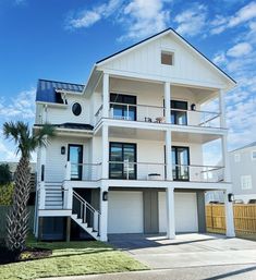 a white two story house with balconies on the first floor and second story