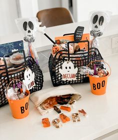 two halloween baskets filled with candy and candies on top of a kitchen countertop