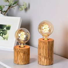 two wooden table lamps sitting on top of a white shelf