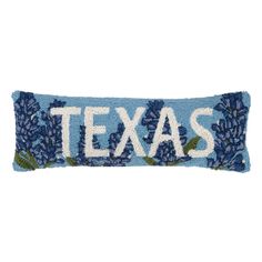 a blue pillow with the word texas on it and flowers in white letters that spell,