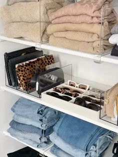 an organized closet with jeans, shoes and handbags on shelves in white shelving