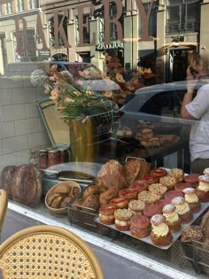 a bakery window filled with lots of pastries and doughnuts in front of it