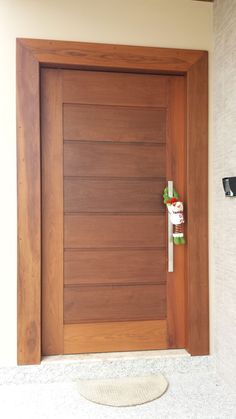 a wooden door with a white towel on the floor next to it and a cup holder in front of it