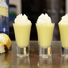 three glasses filled with whipped cream sitting on top of a table