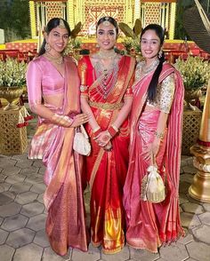 three women standing next to each other in sari