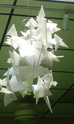 a bunch of white paper stars hanging from the ceiling